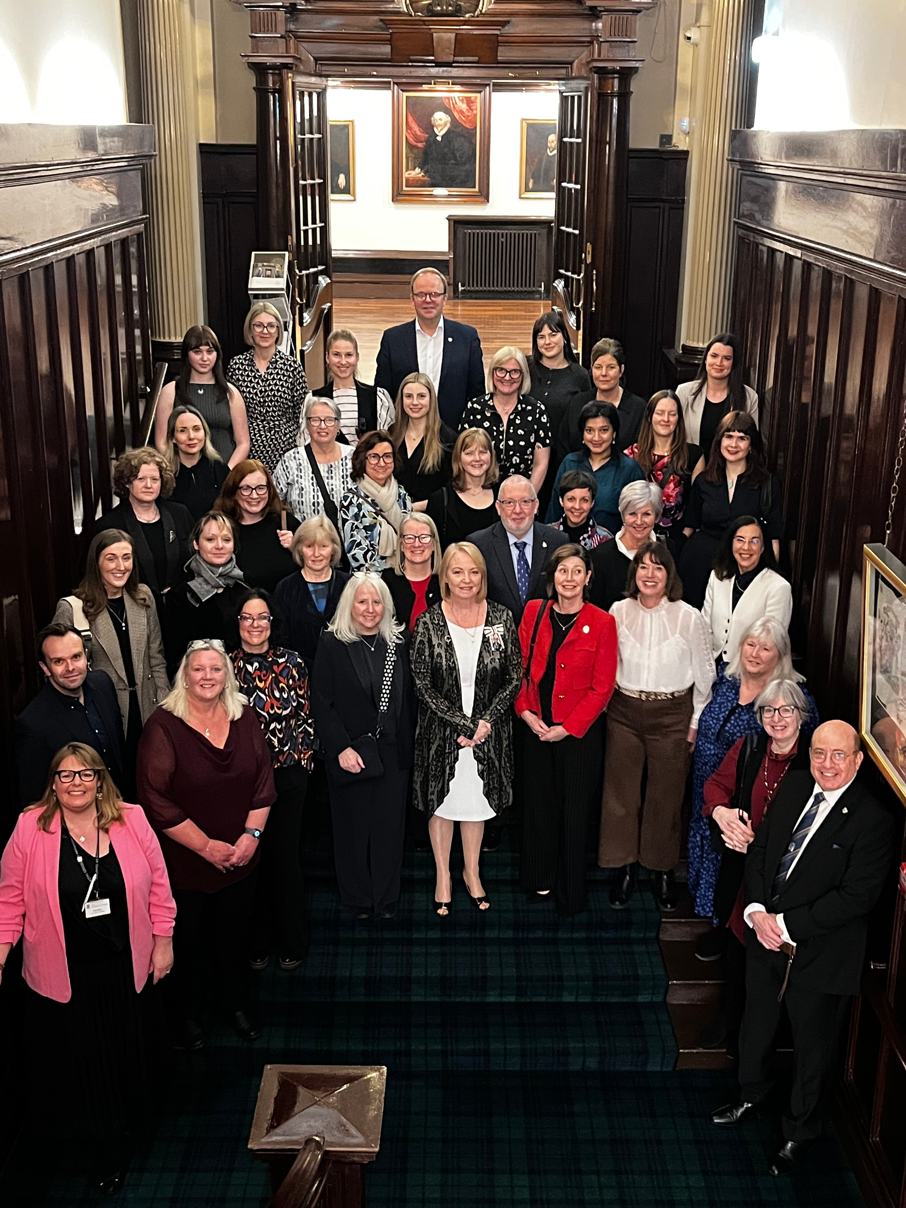 Attendees in group photo in front of College Hall